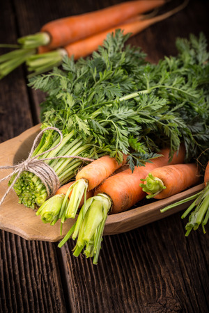 Fresh young bunch of carrots and leaves. Suitable for vegetarians and vegans.の写真素材