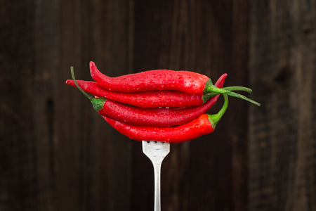 Fresh red chilli pepper on a fork. Organic vegetables.の写真素材