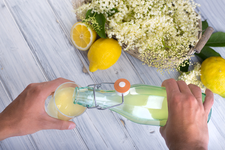 Fresh syrup from nigra sambucus with yellow lemons in glass bottle.の写真素材