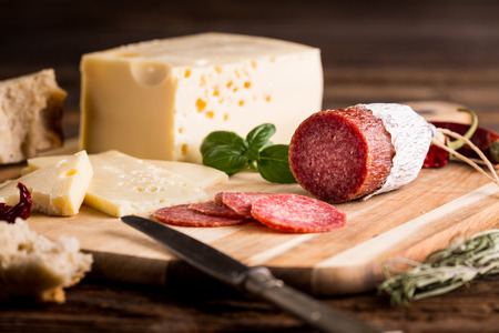 Dry salami or sausage with cheese, bread and herbs.の写真素材