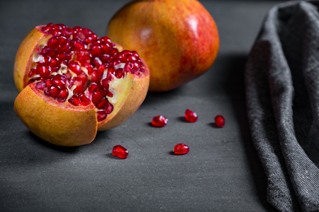Sliced pomegranate with juicy red grains and の写真素材