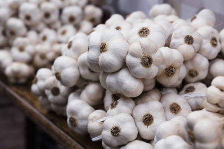 Braid of a organic homemade garlic. Strings of dried garlic in a market.の写真素材