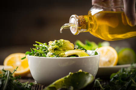 Preparation of avocados in green salad. Vegetables and a bottle of olive oil. の写真素材