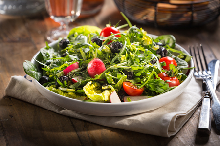Salad with lettuce, tomato,  radish and arugula served on the plate.の写真素材