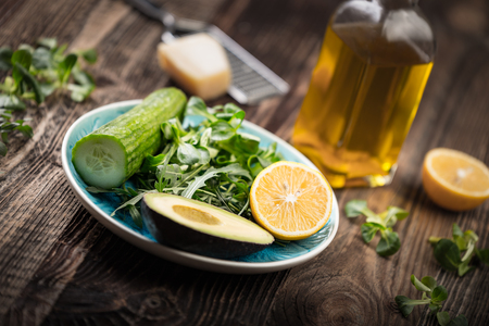 Vegetables and a bottle of olive oil. Ingredients for the preparation of lettuce.の写真素材