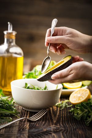 Preparation of avocados in green salad. Vegetables and a bottle of olive oil. の写真素材