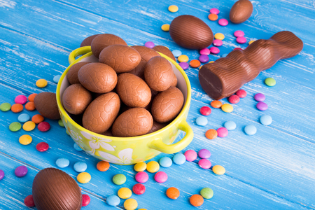 Easter background with chocolate rabbit and a full bowl of Easter eggsの写真素材