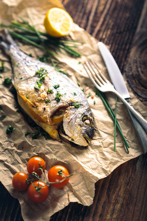 Gilthead seabream (Sparus aurata) baked in the oven with lemon, chive and salt.の写真素材