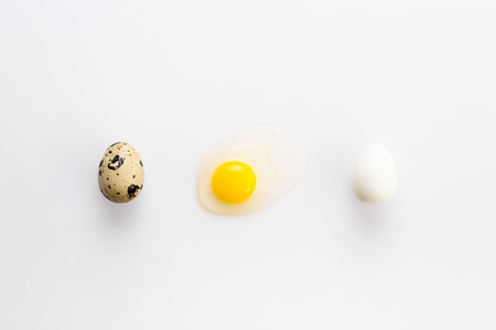 Organic quail eggs on the white background. Boiled and broken egg.の写真素材