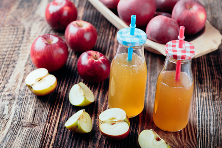 Two bottle fresh organic apple cider or apple juice on the old a wooden table.の写真素材