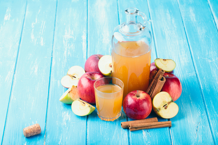 Fresh organic apple cider or apple juice with on the blue background.の写真素材