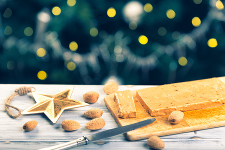 TurrÃ³n is a traditional Spanish sweets. Decorations of almonds and beautiful bokeh.の写真素材
