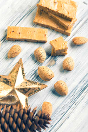 TurrÃ³n is a traditional Spanish sweets. Decorations of almonds on wooden table.の写真素材