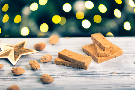 TurrÃ³n is a traditional Spanish sweets. Decorations of almonds and beautiful bokeh.の写真素材