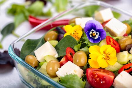 Bowl of vegetable salad with edible flowers.の写真素材