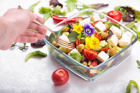 Bowl of vegetable salad with edible flowers.の写真素材