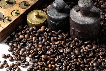 Old rustic metal weights with roasted coffee beans.の写真素材