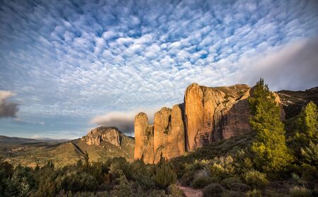 Great blue sky with clouds in a landscape with mountains and forestの写真素材