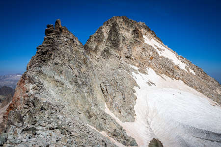 Snow-capped mountain top surrounded by a glacierの写真素材