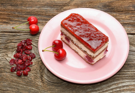 Cherry cake and cherry on wooden background
