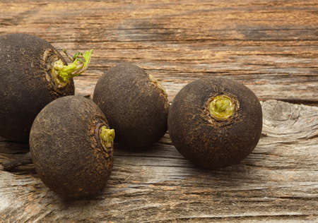 Black radish on wooden backgroundの写真素材