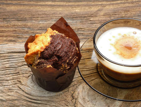 Chocolate muffins and cup of coffee on wooden backgroundの写真素材