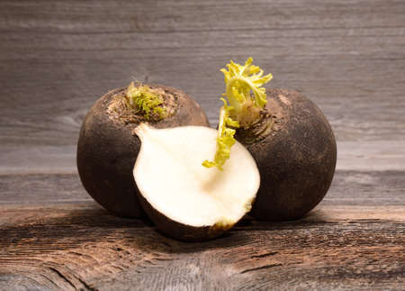 Black radish on wooden backgroundの写真素材
