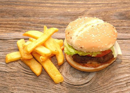 fresh tasty burger and french fries on wooden tableの写真素材