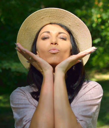 Portrait of beautiful young woman against green lawnの写真素材