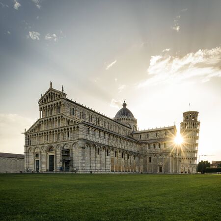 Pisa cathedral and leaning tower at sunrise with spectacular sunburstの写真素材