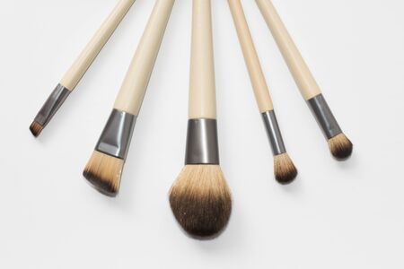Collection of brown makeup brushes on a white backgroundの写真素材