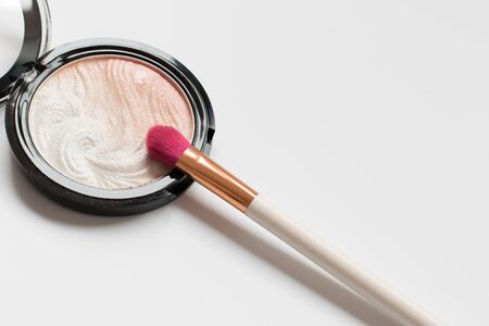 White and pink make up brush and highlighter on a white backgroundの写真素材