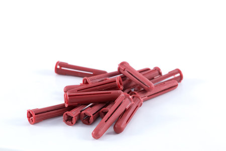 Red wall plugs or screw anchors on white surface