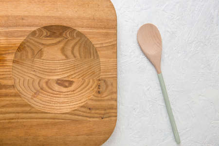 Decorated wooden spoon and chopping board on white の写真素材