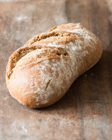 Artisan Brown Rye Bread on wood chopping board