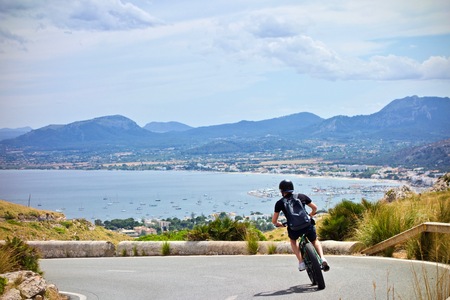 Downhill e-bike in Majorca with scenic mountains and Mediterran Sea in the backgroundの写真素材