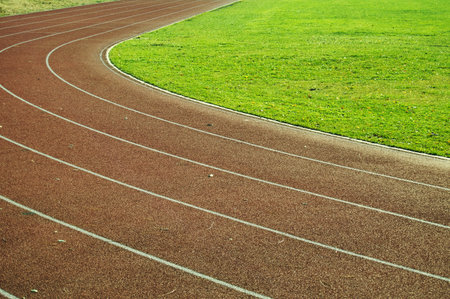 Running tracks in the stadium, detail of a running track with green grassの写真素材