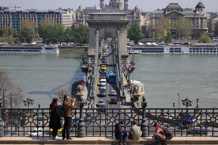 Budapest, April 2019: Tourists taking pictures in front of Chain bridge at Danube river.のeditorial素材