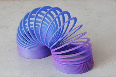 Bern, may 2019: The spiral, a 90s toy for kids. Blue and violet spiral against white background.のeditorial素材