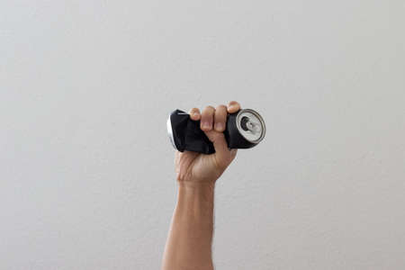 Hand crushing used can representing movement against pollution and for recycling.の写真素材