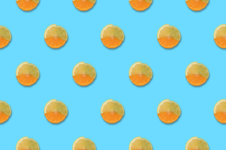 Lemon, orange and lime slices pattern on blue background. Minimal trendy Summer or Spring concept.の写真素材