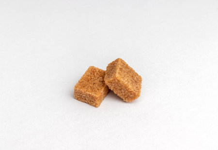 two pieces Brown cane sugar cubes isolated on white backgroundの写真素材