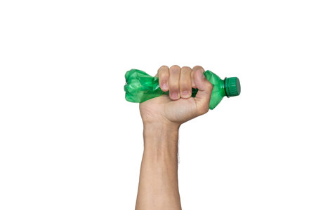 Plastic bottle recycling or pollution concept. Hand squeezing or crushing a green plastic bottle isolated on white backgroundの写真素材