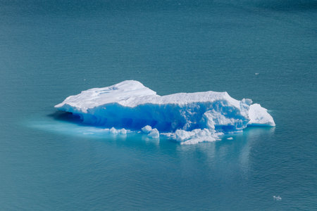Ice block floating in blue water and merlting awayの写真素材