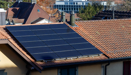 Solar panel on a roof in a typcial swiss neighbourhood.