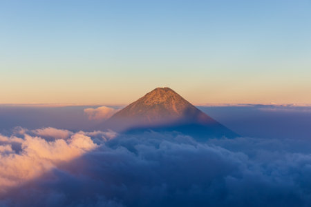 Volcano agua in guatemala through backlit clouds at sunset seen from acatenango hiking.の写真素材