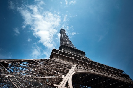 Eiffel Tower in Paris shot from Champs de Mars against a blue sky shoto from unusual angle. Useful file for your brochure, flyer and website about french culture and architecture.の写真素材