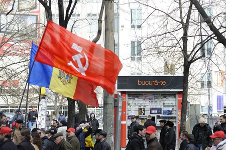 Communist flag in fornt of Moldavian flag during the march of more than 10 thousand people who protest against the current administration and president elections.のeditorial素材