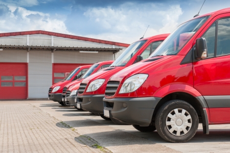 Row of red delivery and service cars in front of a factory and warehouse distribution plantのeditorial素材