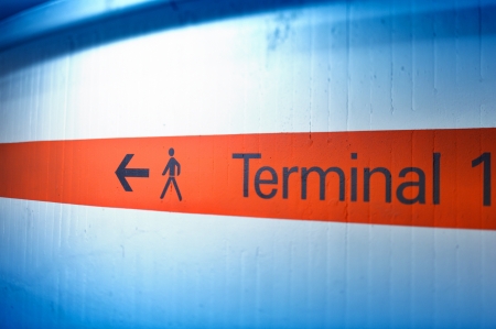Informational sign on red stripe showing terminal number  one  at international airportの写真素材